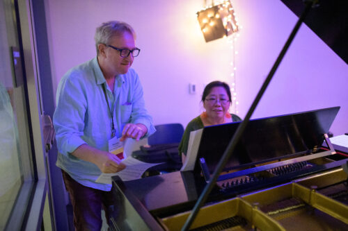 MFA in Music Composition faculty Rick Baitz and Trudy Chan at a piano 