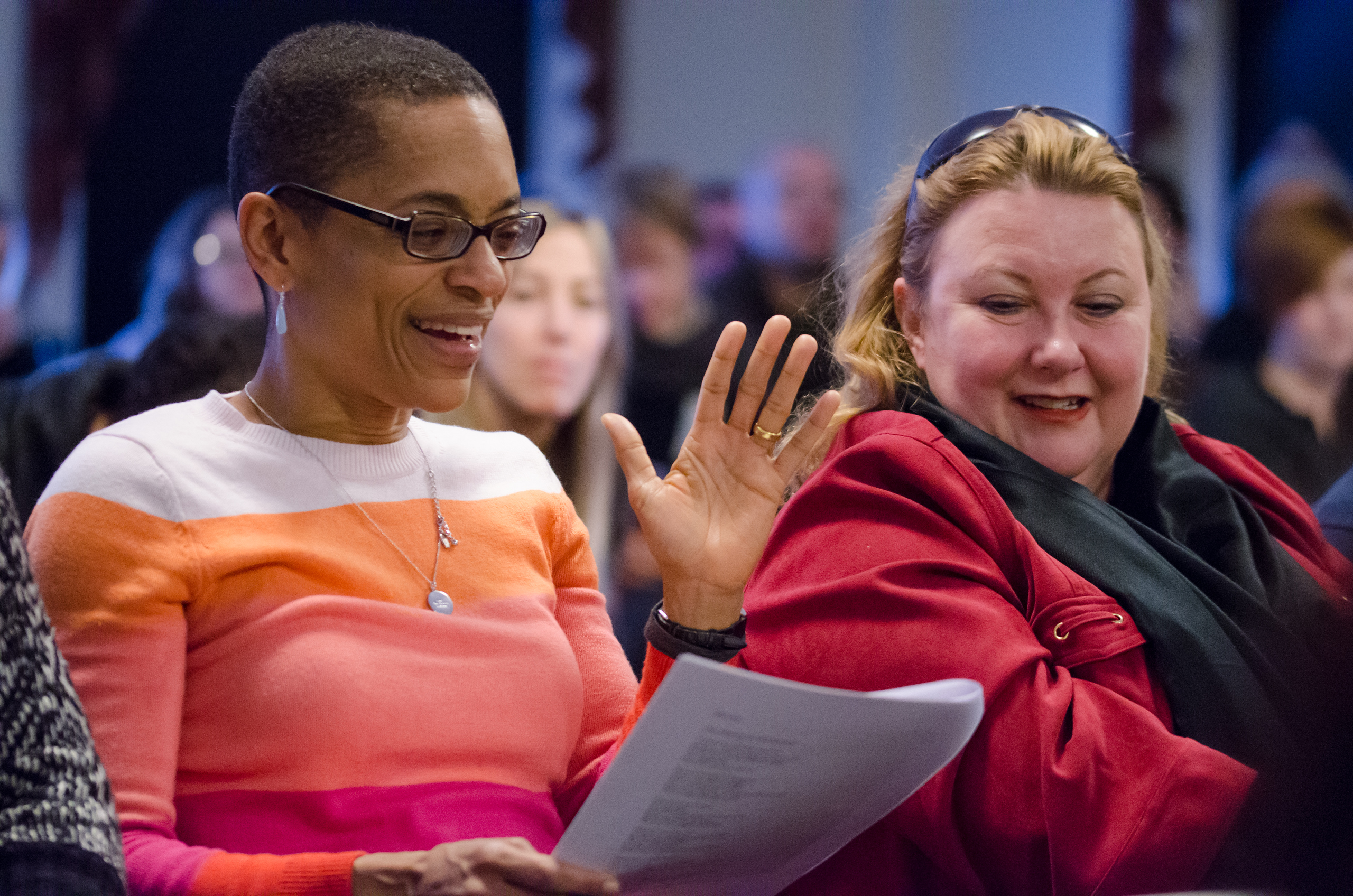 Smiling VCFA writing students discuss how to write faster during a writing event.
