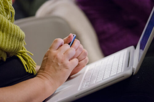 A VCFA writing student takes notes on a laptop while studying how to write faster.