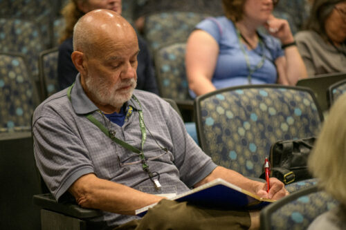 A VCFA writing student takes notes during a lecture on how to write faster.