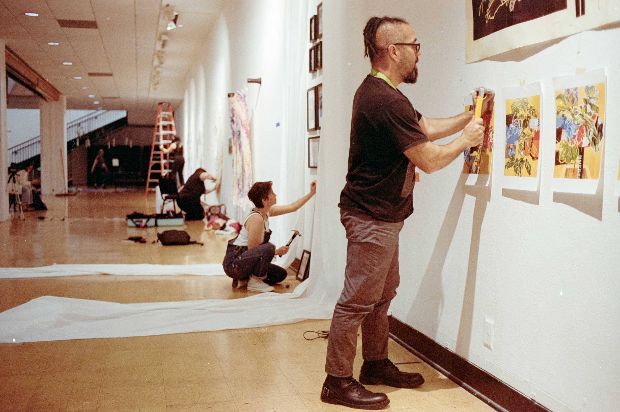 VCFA visual art students hang art in a gallery after paying vcfa tuition.
