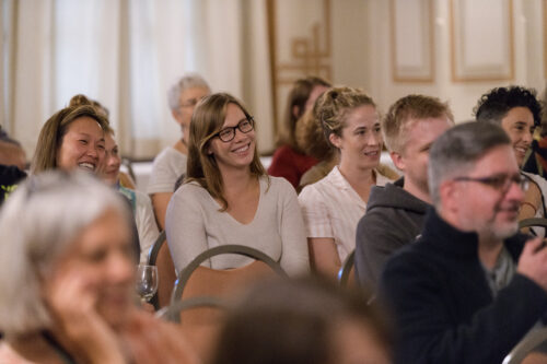 Students laugh during a lecture on writing prompts.