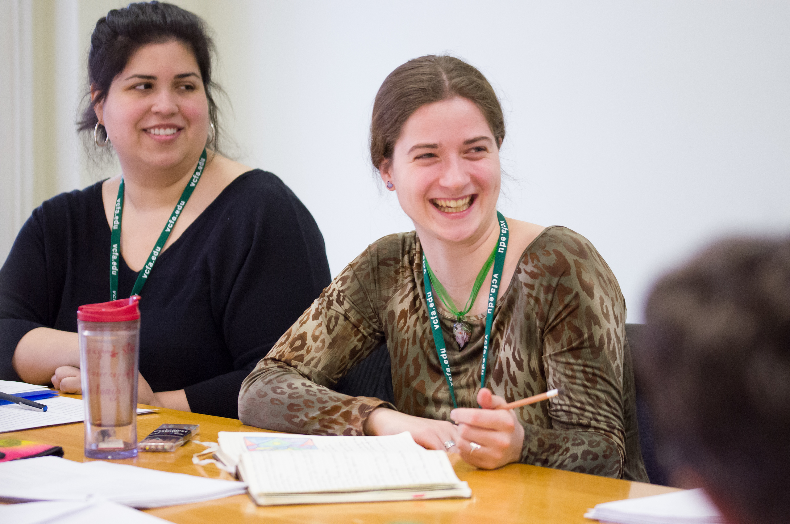 VCFA students smile during a craft conversation about writing YA horror stories.