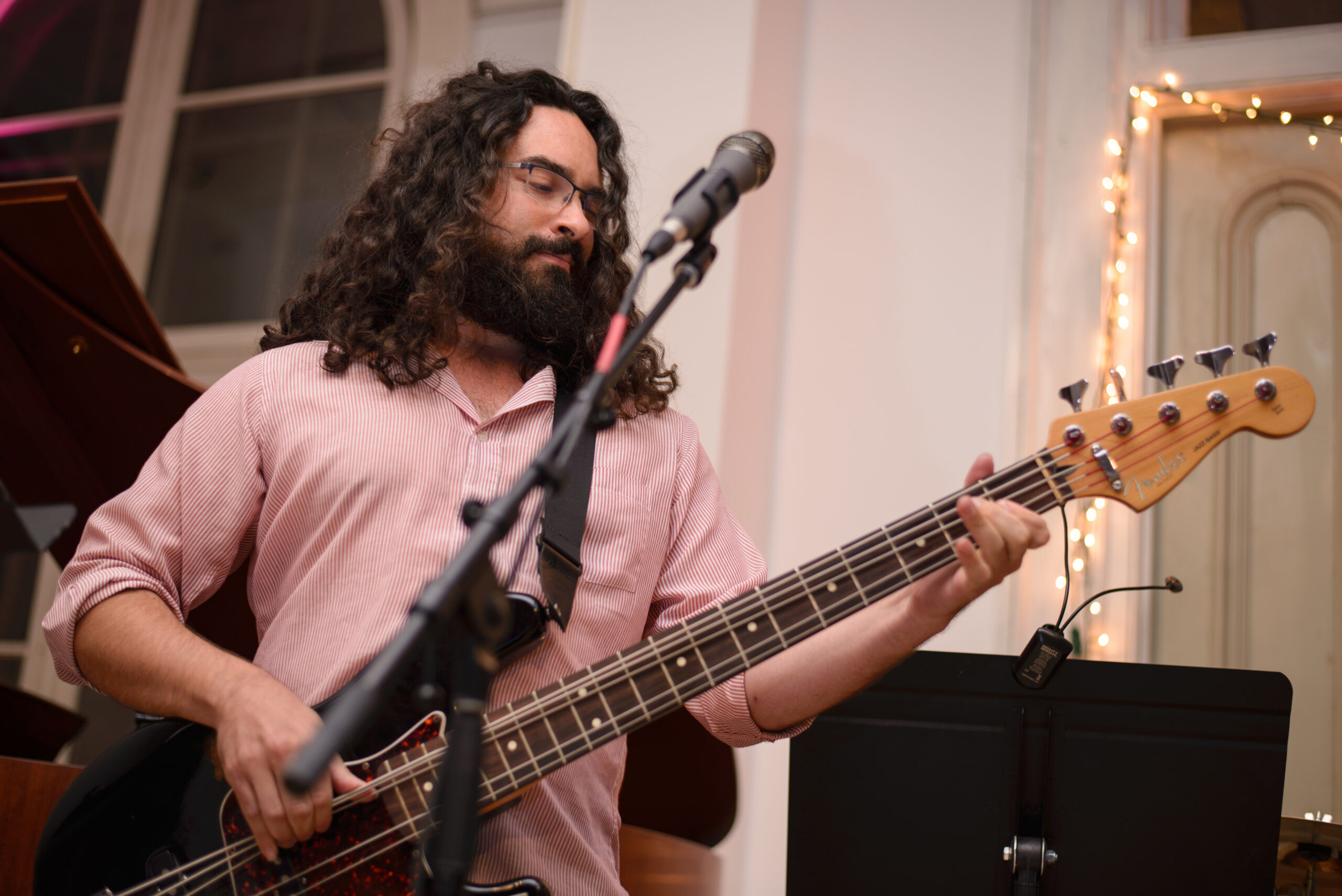 A VCFA student smiles while playing the bass during a performance.