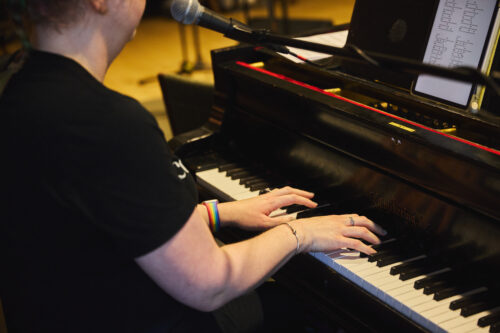 VCFA Music Composition student plays the piano after studying music theory.