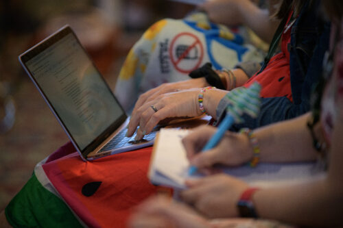 VCFA students type notes onto a computer during a lecture about what is prose.