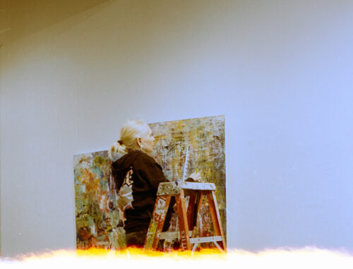 VCFA student hangs art in a gallery during residency.