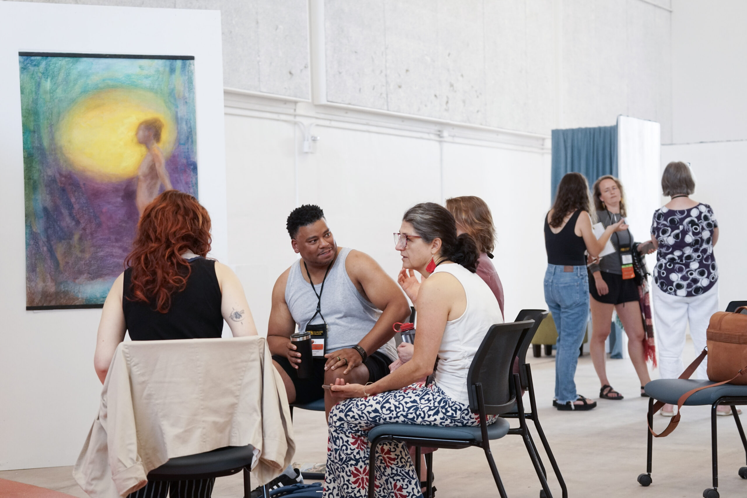 VCFA visual art students smile and discuss art and artist grants.
