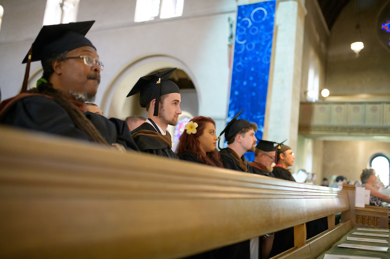 A line of students wearing graduation hats inside of Shove Chapel.